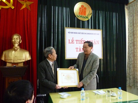 Ông Nguyễn Văn Rinh trao chứng nhận "Tấm Lòng vàng" cho nhà văn Phương Lựu. (Ảnh Thu Hòe)